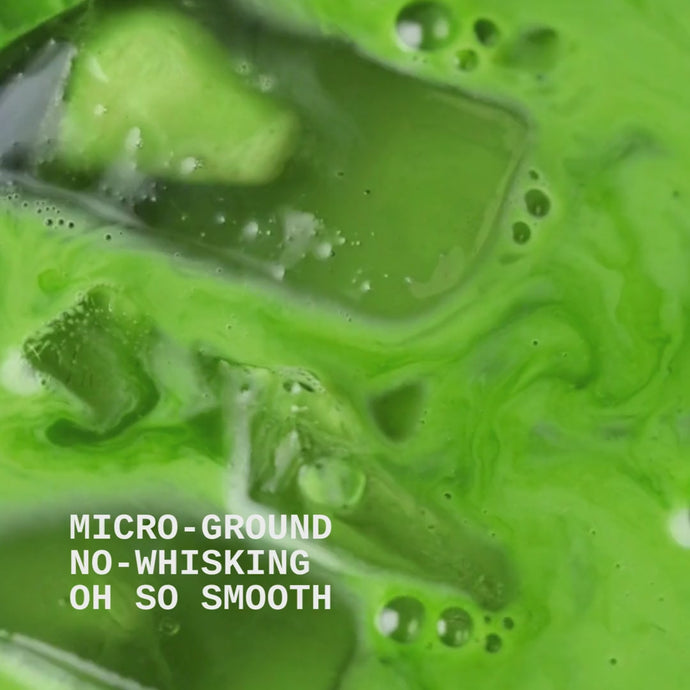 Close up of green matcha iced latte being slowly stirred